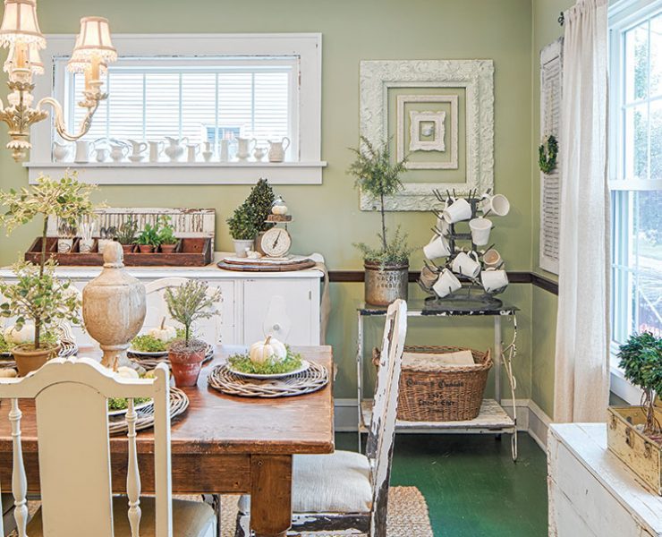 dining room with farmhouse table and green walls in flea market inspired farmhouse