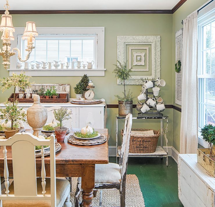 dining room with farmhouse table and green walls in flea market inspired farmhouse