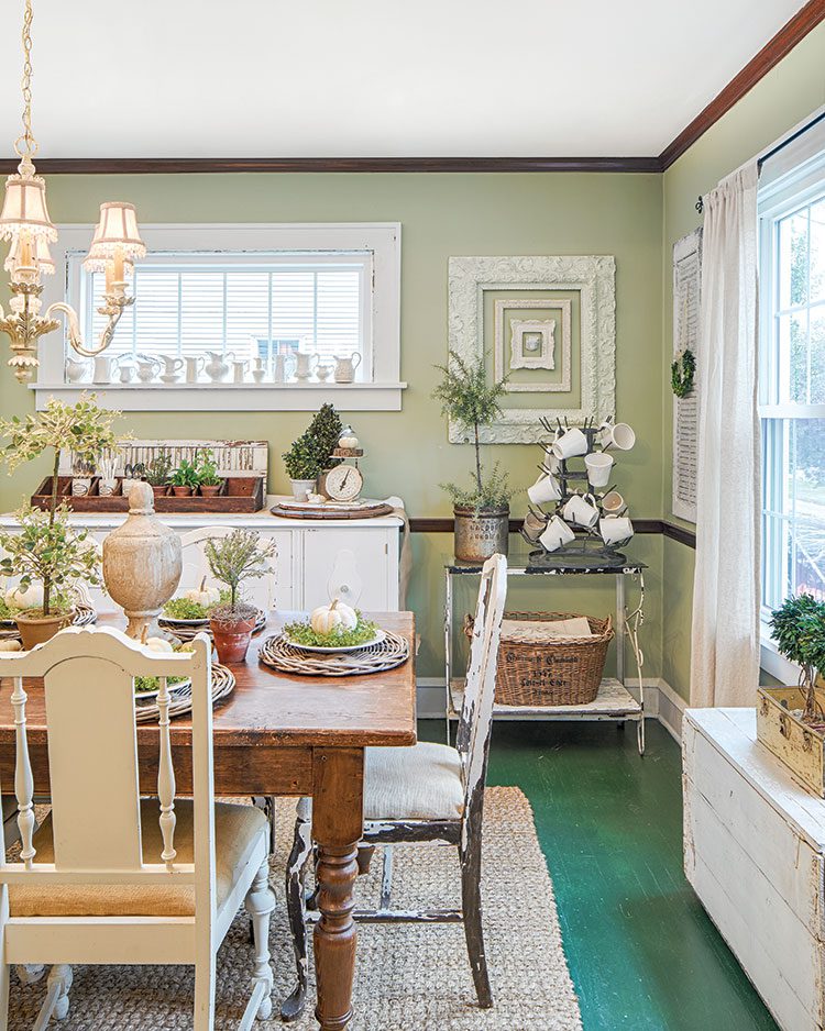 dining room with farmhouse table and green walls in flea market inspired farmhouse