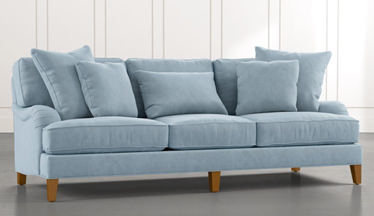 Light blue couch with matching pillow set on top and wood peg legs.