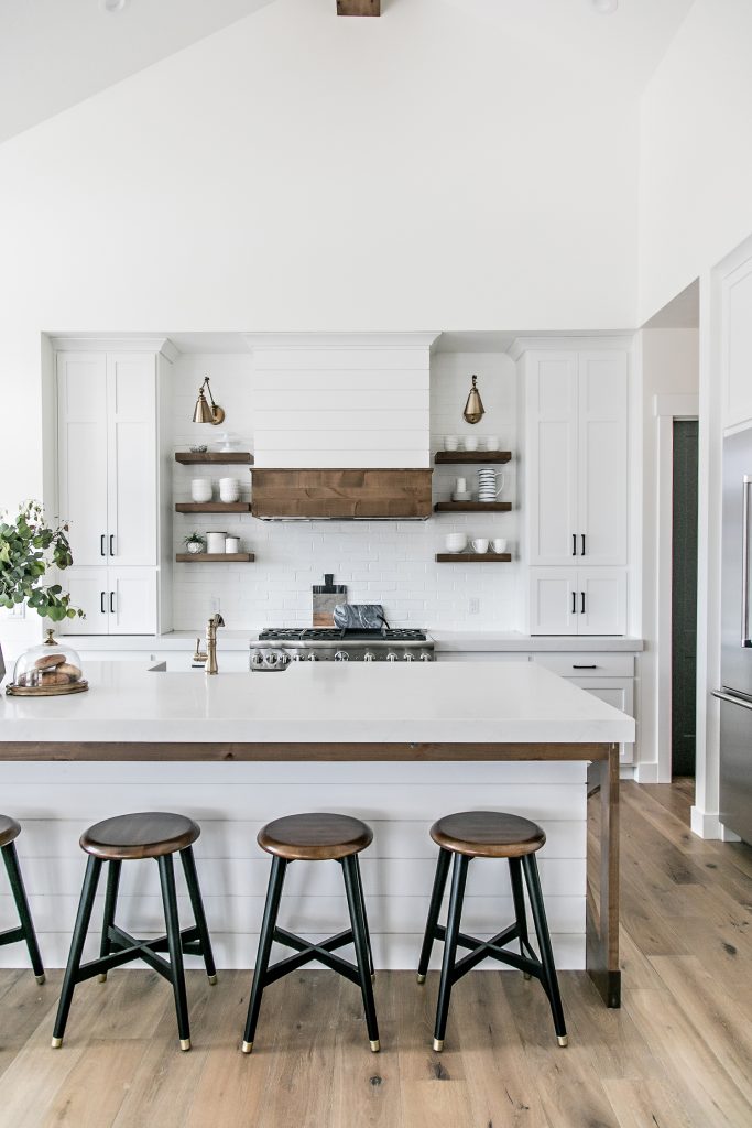 white kitchen with dark wood accents and barstools in modern farmhouse style