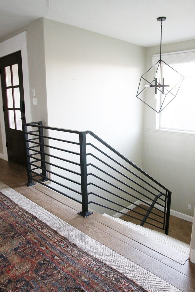 modern staircase with metal railings light and rug