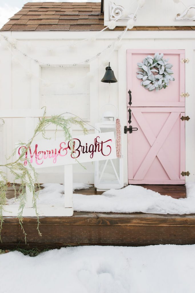 white and pink playhouse with merry and bright sign