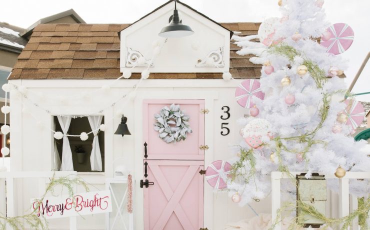 Exterior of playhouse with pink door and white Christmas tree