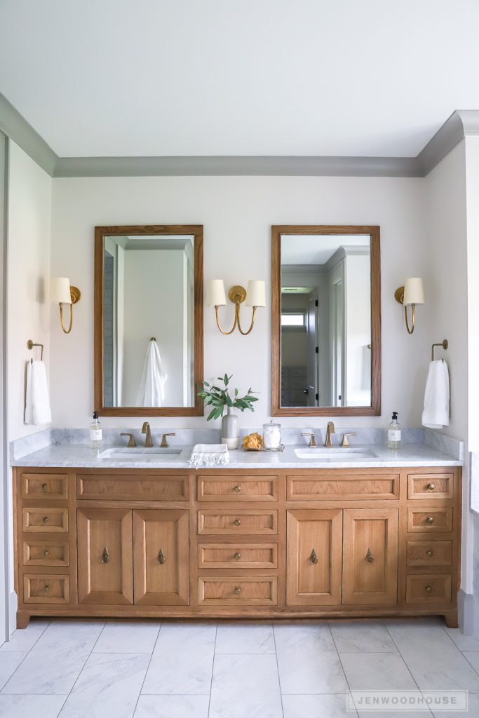 modern farmhouse style bathroom with wooden vanity and two mirrors marble countertops