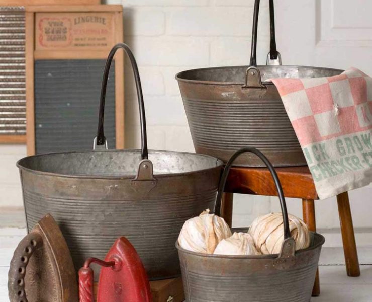 Three different-sized rustic metal buckets with black handles.