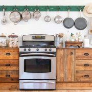 vintage wood cabinets and oven and pot rack in kitchen in ranch renovation