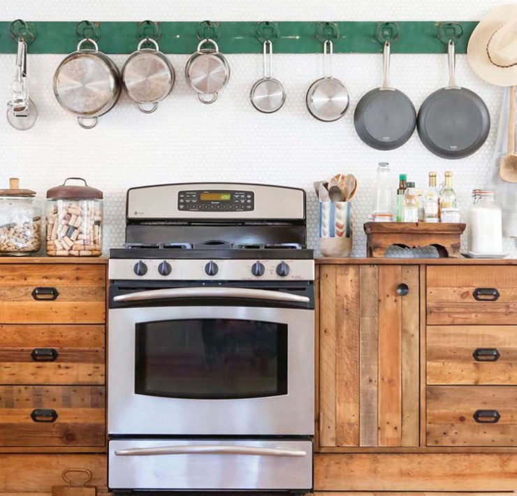 vintage wood cabinets and oven and pot rack in kitchen in ranch renovation