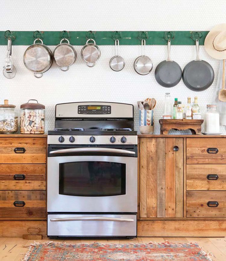 vintage wood cabinets and oven and pot rack in kitchen in ranch renovation