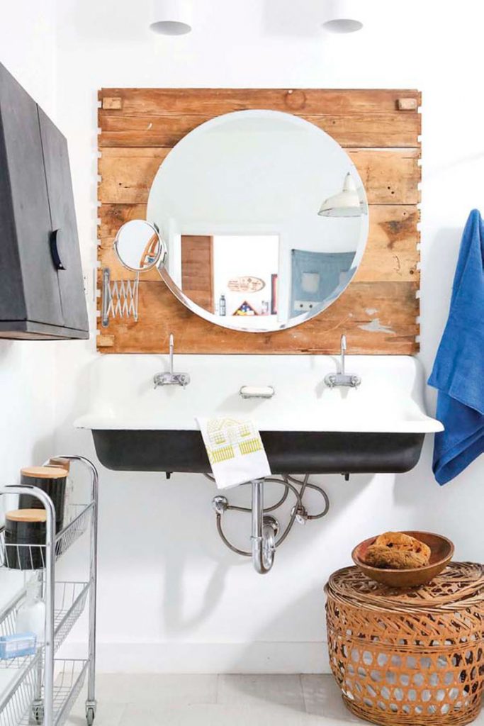 bathroom with round wood mirror black sink in ranch renovation