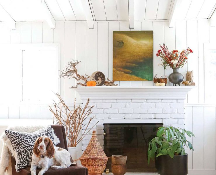 white brick fireplace next to gray chair with dog