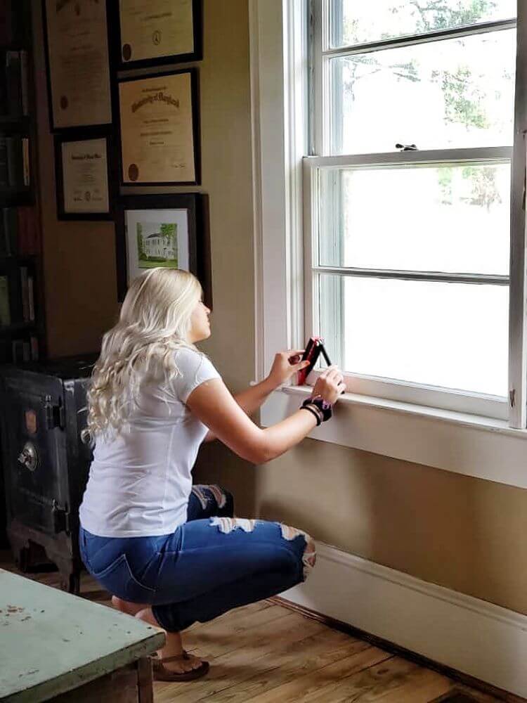 A woman measures her window