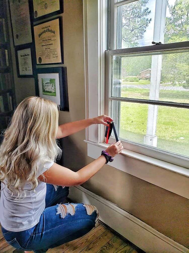 A woman measures her window