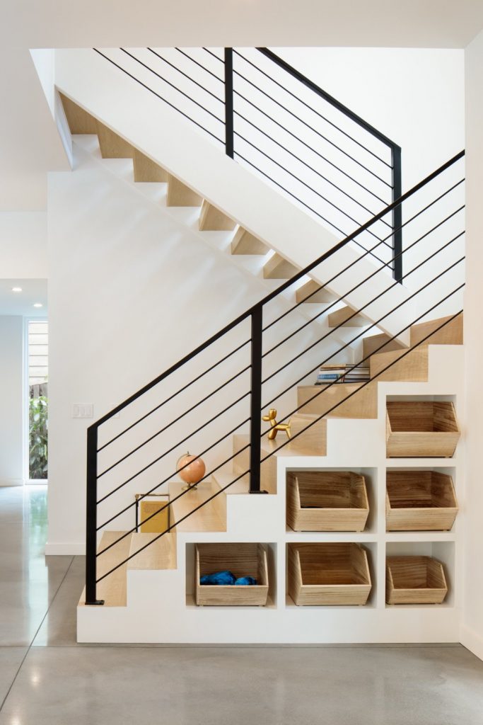 modern staircase with metal railing and built in cubby