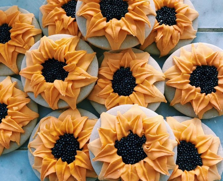 A colorful arrangement of sugar cookies with sunflower designs on each individual dessert