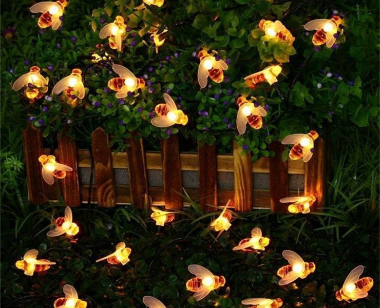 Country bridal shower string lights in the shape of honeybees spread out across a hedge