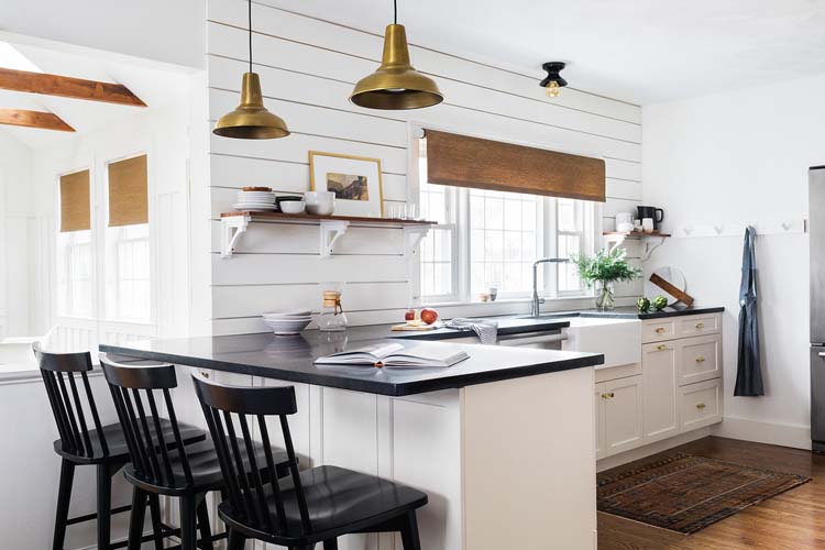 Scandinavian farmhouse style kitchen with window white cabinets and black countertops