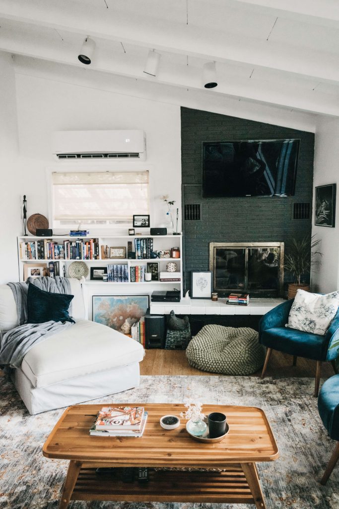 scandinavian farmhouse style living room with fireplace rug bookshelves blankets white walls