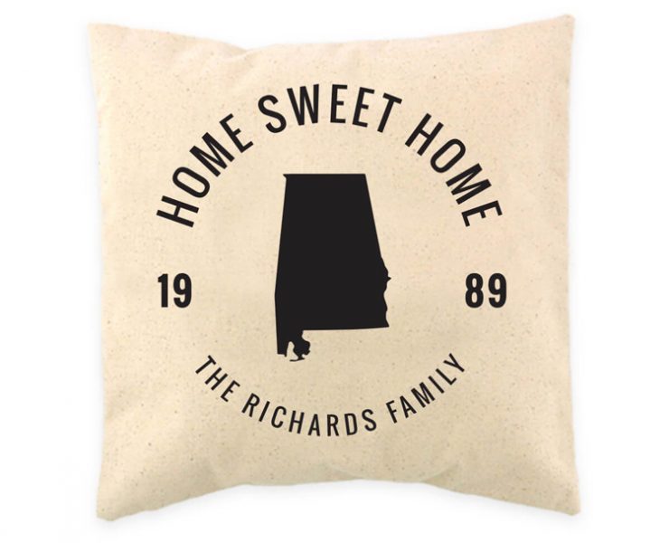 Cream colored pillow with black circular writing around a state silhouette.
