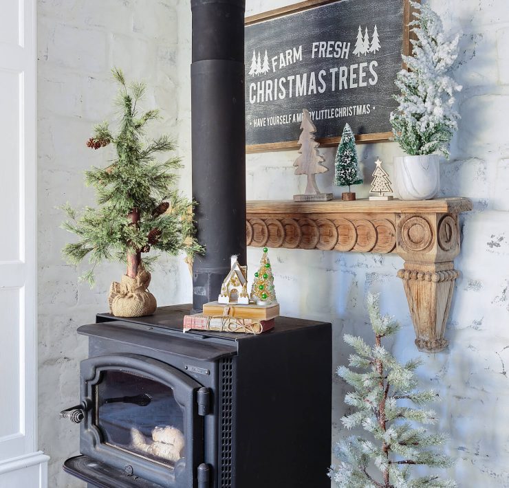 Rustic wood stove with Christmas Trees sign for a woodland Christmas theme.