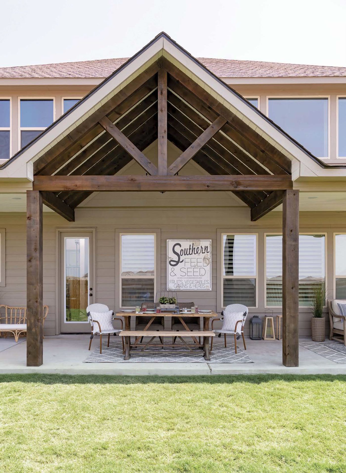 The exterior of this Texas farmhouse has a broad triangular archway over a table ready for guests!