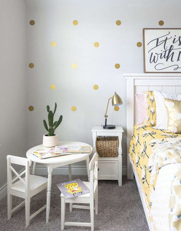 This modern Texas farmhouse bedroom has DIY metallic gold polka dots painted onto the gray wall behind the bed.