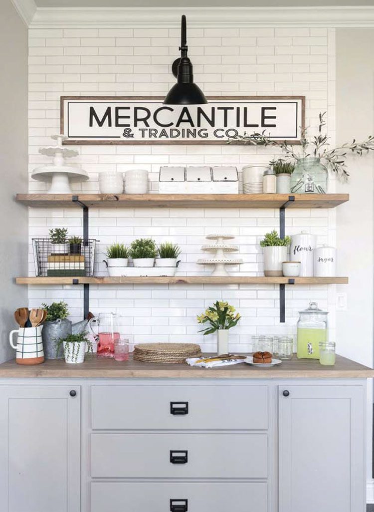 This Texas farmhouse kitchen has a white and black old-fashioned "Mercantile" sign outlined with a wood frame.