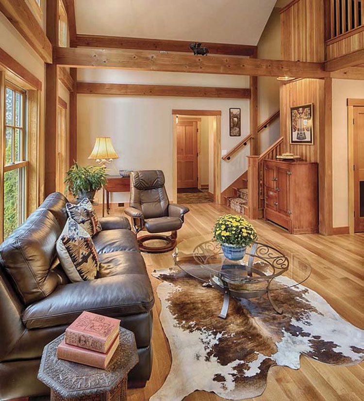 The living room example has wood flooring and paneling with a cow-hide rug and leather couches. It's the cozy vibe we want for our New Hampshire farmhouse.