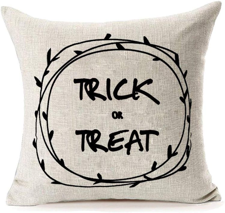 This off-white pillow says "Trick or Treat" with a modern black wreath circled around the words.