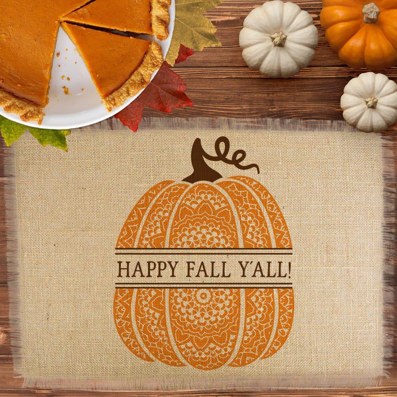 This burlap place mat has a fringe border and a patterned pumpkin that has a personalized message running through the middle.