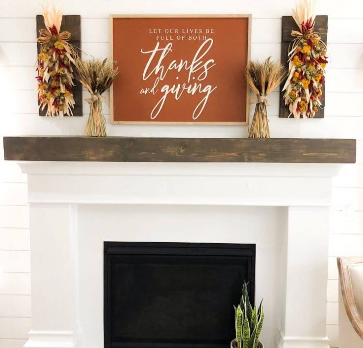 white fireplace with This Is Us sign and fall mantel