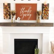 white fireplace with This Is Us sign and fall mantel
