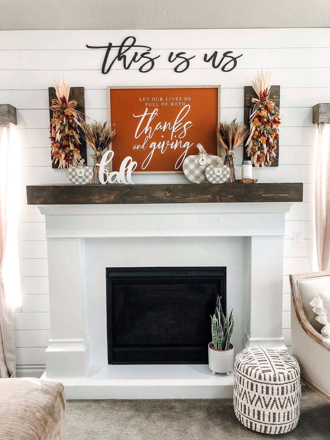 white fireplace with This Is Us sign and fall mantel