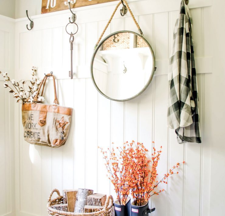Nina's mudroom uses everyday items to create a chic upcycled fall look. She has a flannel hanging by a hook above rain boots-turned planters and a woven basket.