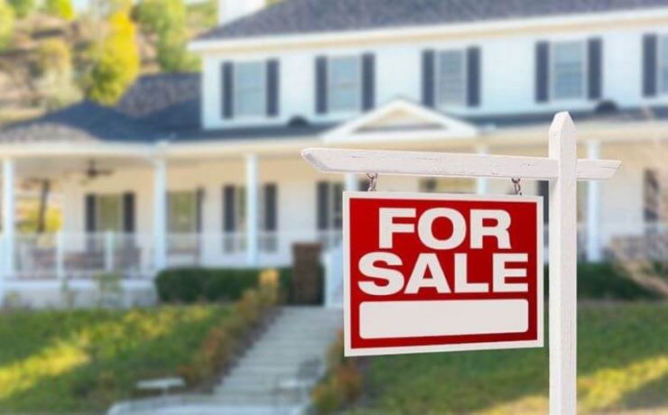 Picture of a for sale sign in front of a home