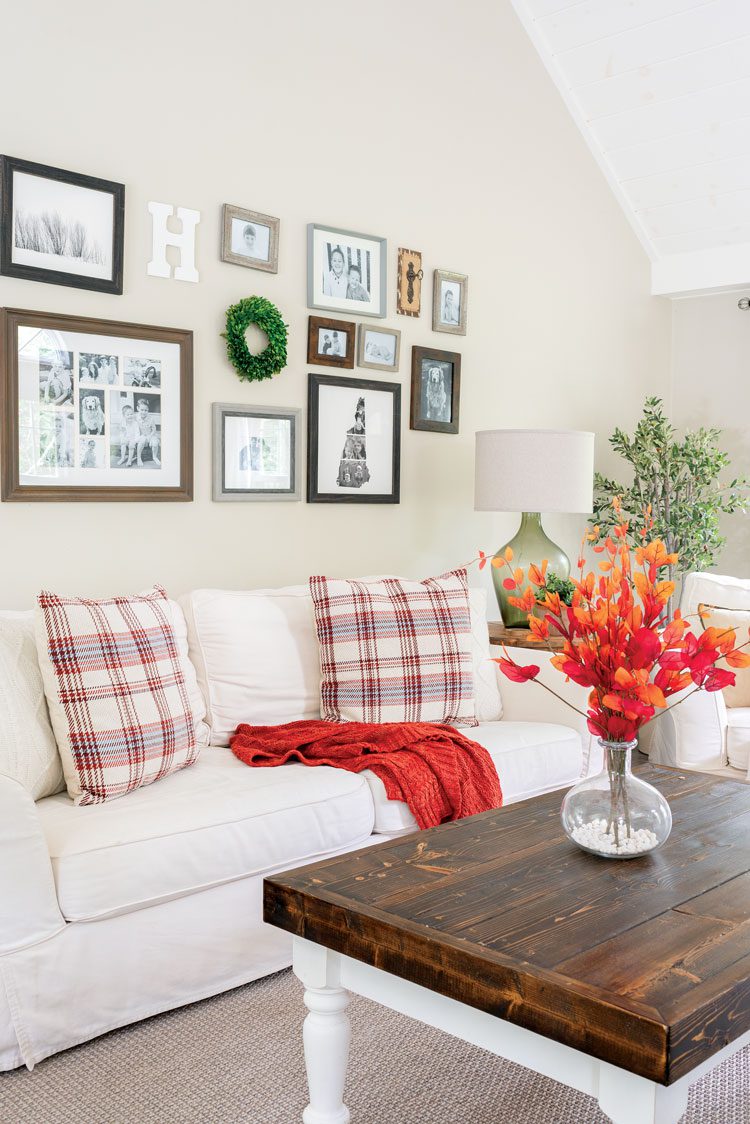 Nina created a wall gallery above her living room couch with different-sized family photos, a small green wreath and the letter "H" for "Hendrick".