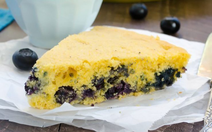 This Thanksgiving recipe shows a slice of cornbread with whole blueberries baked into the bottom half.