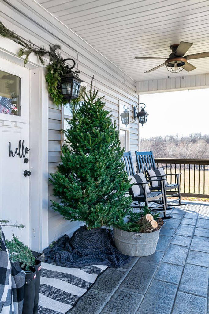 Decorate with Christmas trees like this covered porch with a plain green tree