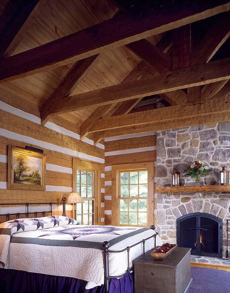 A bedroom in a cabin-like room with rafters.