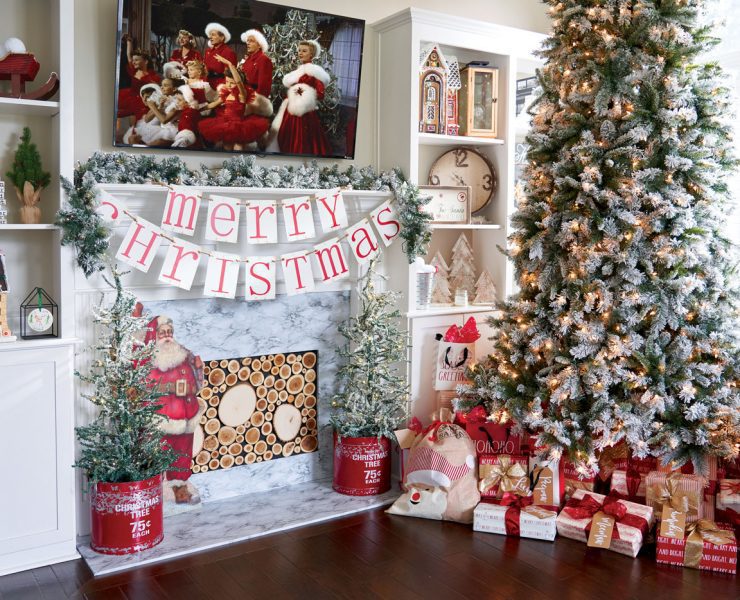 Jenna's toddler looks up at her lit, snow crusted Christmas tree in their family friendly Christmas house.