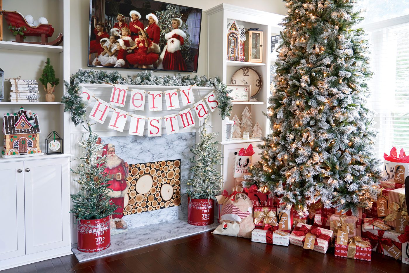 Jenna's toddler looks up at her lit, snow crusted Christmas tree in their family friendly Christmas house.