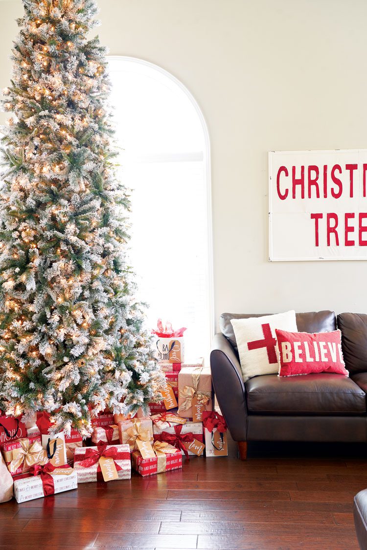 Jenna's Christmas tree with many red, white and gold presents beneath it in their family friendly Christmas house.