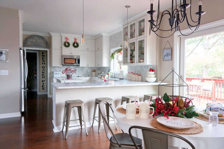 The primarily white and off-white kitchen with barstool seating in Jenna's family friendly Christmas house.