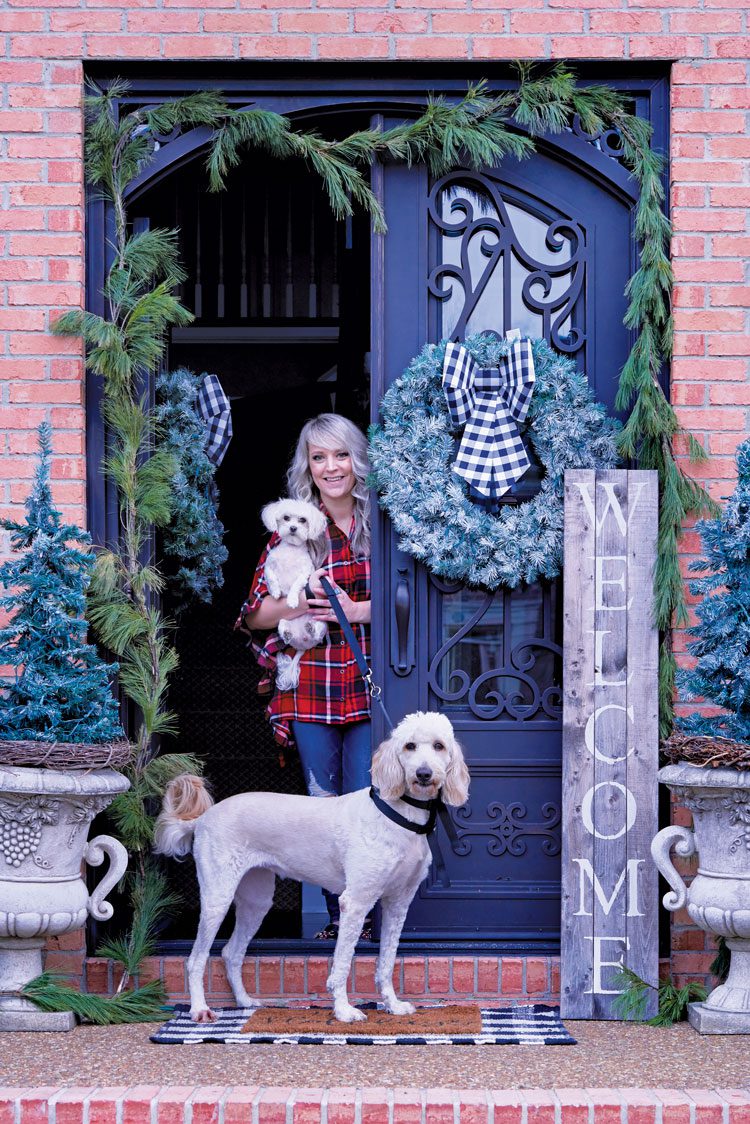 Jenna and her two dogs opening the door to their family friendly Christmas house.