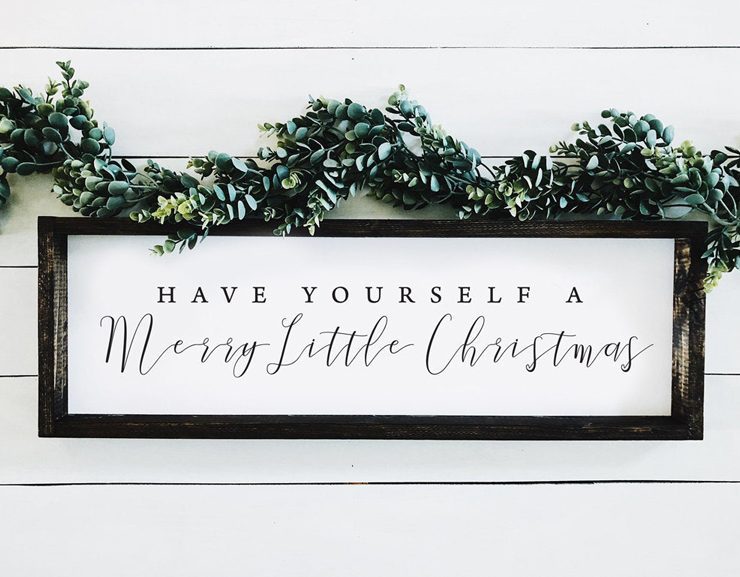 White and black "Have yourself a merry little Christmas" rectangular sign in mixed fonts.