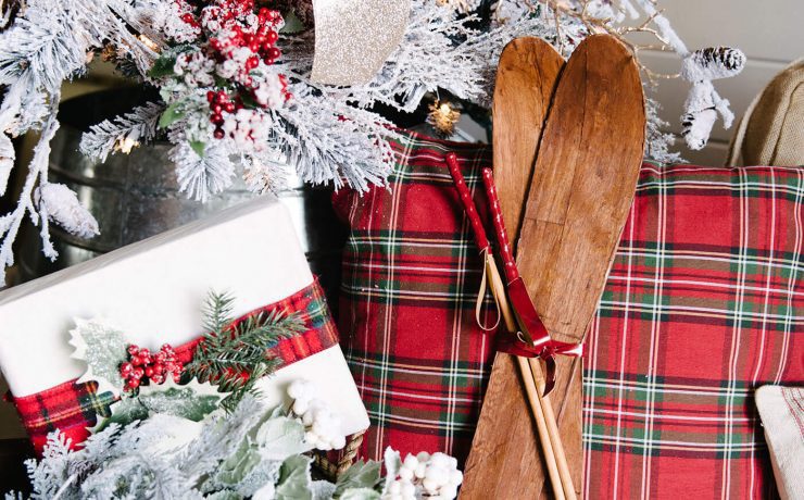 White gift wrap on packages with red embellishments under a Christmas tree