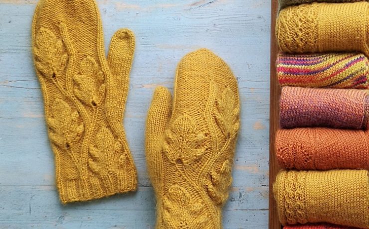 Two mustard-colored knit mittens with a leafy design knitted into them in true country winter fashion.