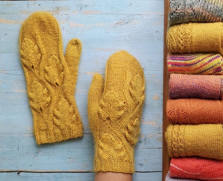 Two mustard-colored knit mittens with a leafy design knitted into them in true country winter fashion.