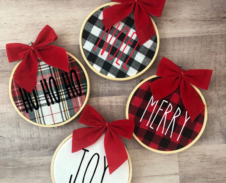 4 circle fabric ornaments with wood frames and red bows. Each one has a holiday word stitched onto it, for Etsy Christmas decor