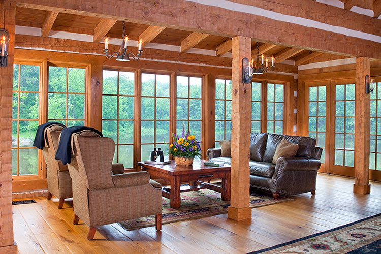 Wooden columns extend down around a family room filled with comfortable armchairs.